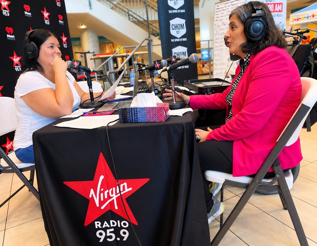 Caline Saleh, wearing headphones, speaks into a microphone at the Virgin Radio 95.9 table during the radiothon.